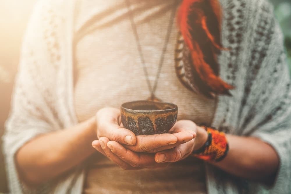 woman holding plant medicine cup before ayahuasca integration - third wave blog image